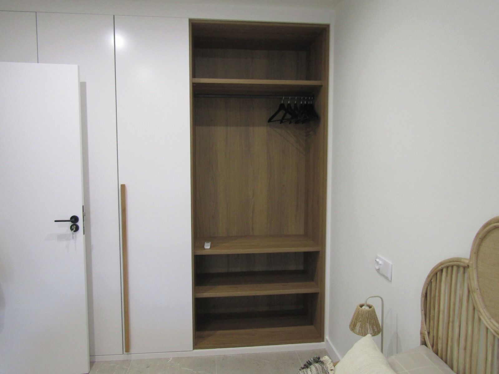 Une chambre avec une armoire, un lit et une lampe de chevet.