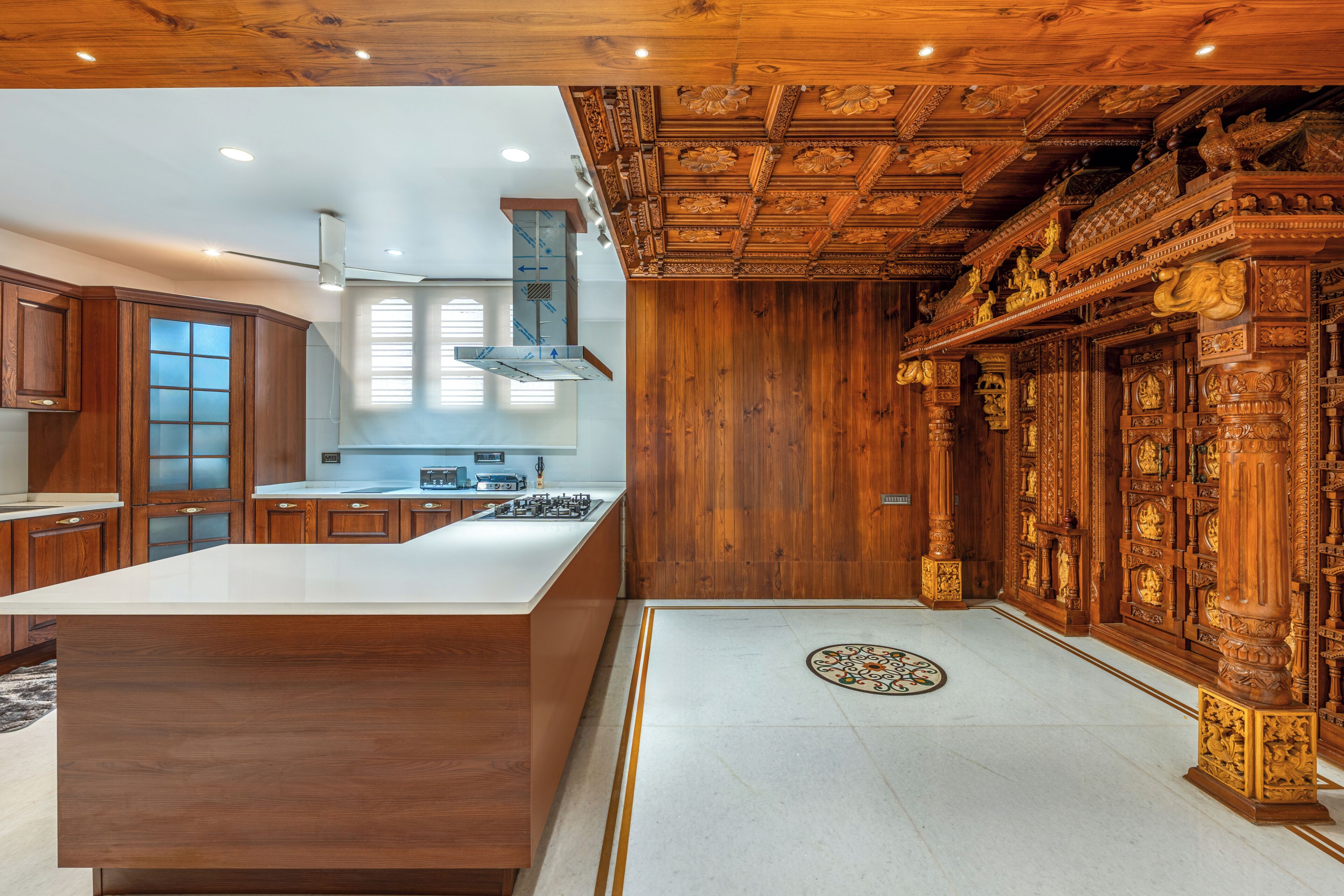 A spacious kitchen with a large island, wooden cabinetry, and a decorative ceiling.