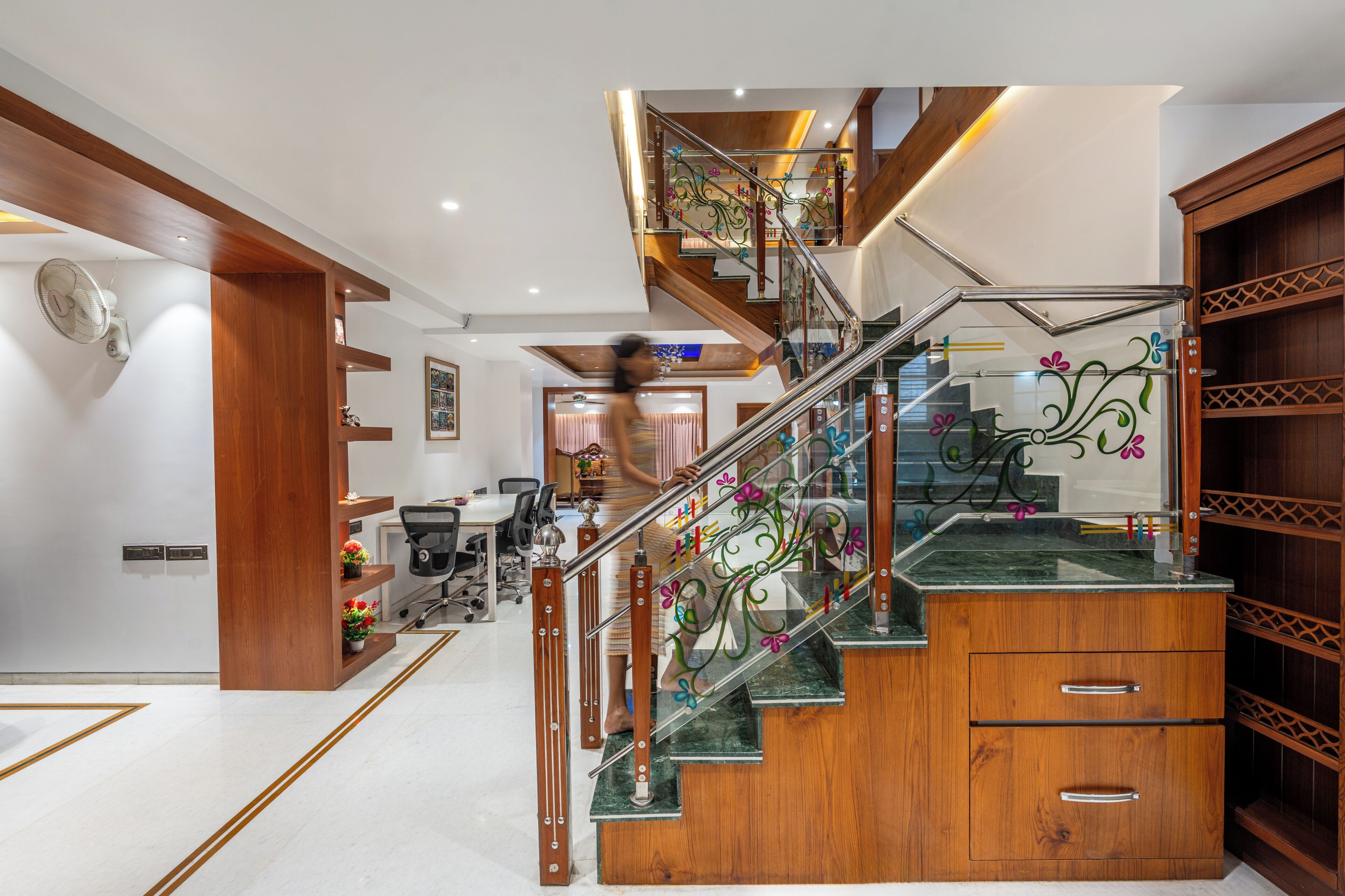 A modern interior with a wooden staircase, a desk, and a chair.