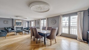 Una sala da pranzo con pavimento a spina di pesce, un tavolo rotondo e sei sedie.