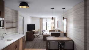 A modern kitchen with a microwave, a flat-screen TV, and a dining area with a table and chairs.