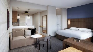 A hotel room with a bed, a sofa, a table, a chair, a small kitchen area, and a bathroom. - Residence Inn by Marriott San Antonio Riverwalk (San Antonio)