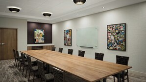 A conference room with a long wooden table, black chairs, and three ceiling lights. - Residence Inn by Marriott San Antonio Riverwalk (San Antonio)