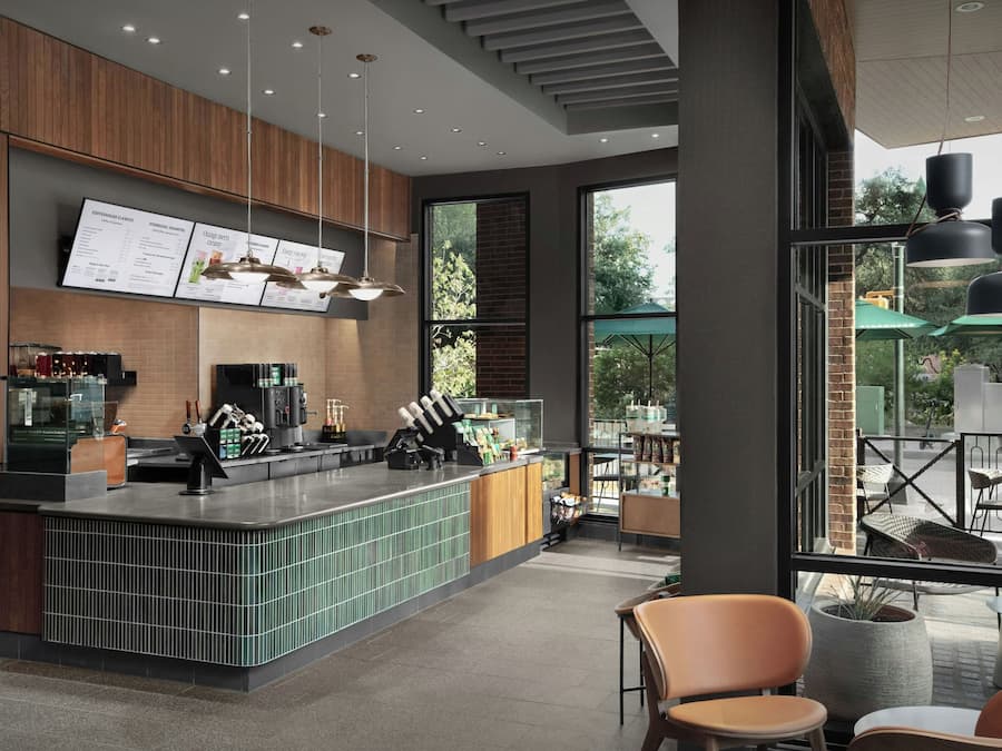 Interior moderno de café com balcão, cardápios e mesas.
