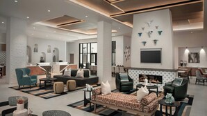 A spacious living area with a fireplace, seating arrangements, and a television mounted on the wall. - Residence Inn by Marriott San Antonio Riverwalk (San Antonio)