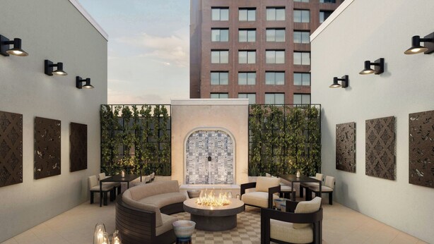 A modern outdoor seating area with a fire pit, lounge chairs, and decorative wall art.