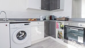 Eine moderne Küche mit Waschmaschine, Mikrowelle und Backofen.