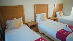 Three single beds with wooden headboards, white bedding, and small wooden nightstands with lamps. - Apartment downtown Agadir 10 min from the beach (Agadir)