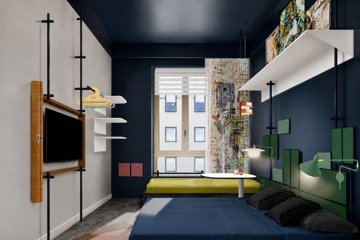 A modern bedroom with a bed, a TV, a desk with a lamp, and artwork on the walls.