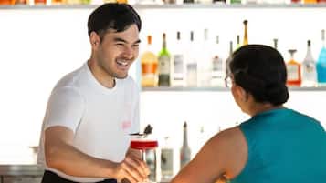 Um bar com um bartender e um cliente.