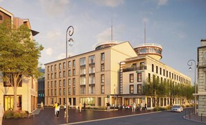 A modern building with a central atrium, multiple floors, and a distinctive rooftop structure. - Ibis Styles Saint Germain En Laye (Saint-Germain-en-Laye)