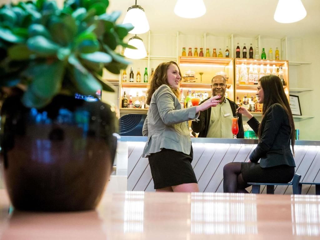 A bar area with a counter and shelves of bottles.