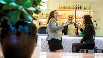 Een bar met een toonbank en flessenkasten.