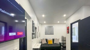 Una camera d'albergo moderna con un letto, un piccolo tavolo e uno schermo televisivo che mostra un'interfaccia di accesso.