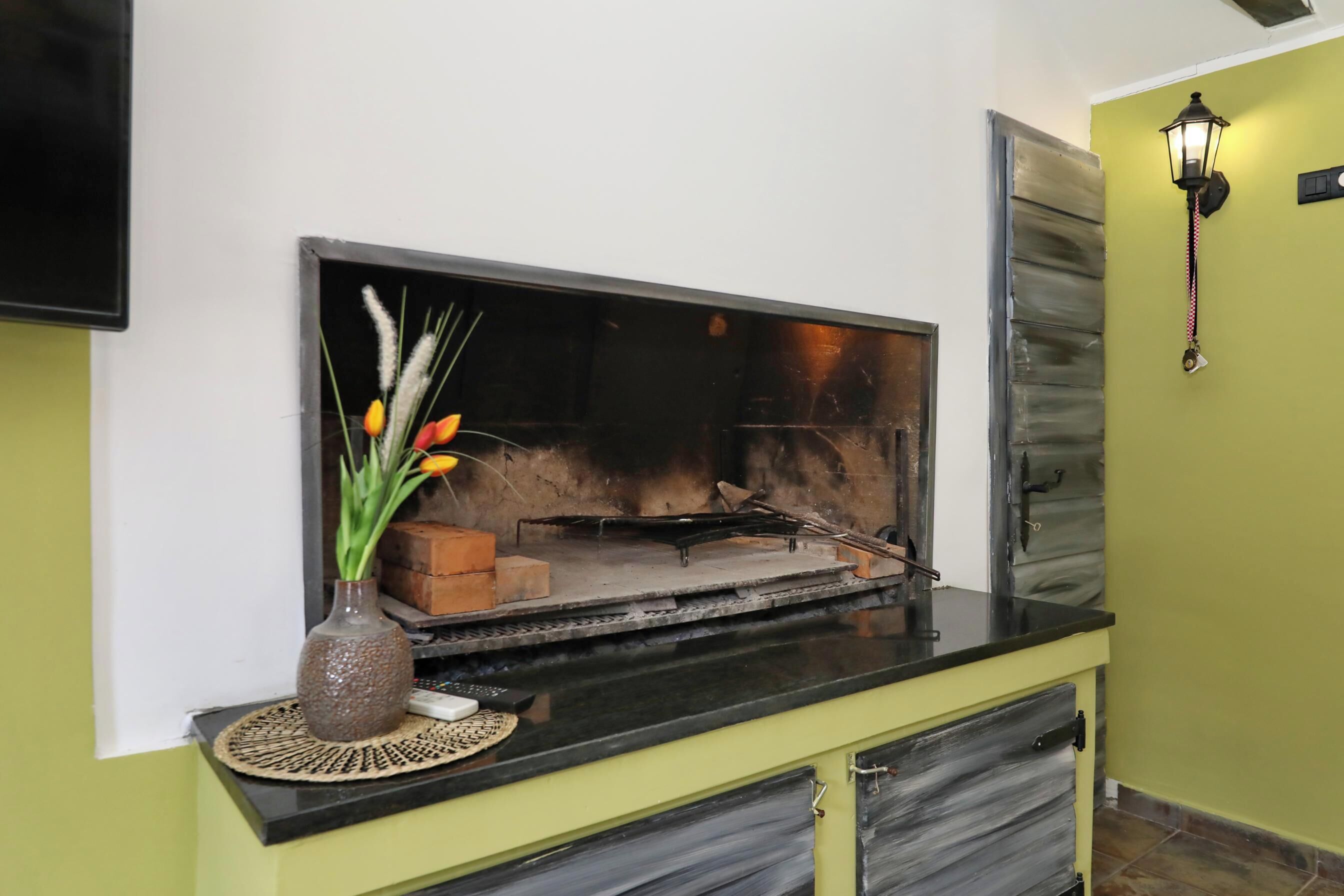 A flat-screen TV mounted on a wall, a decorative vase with flowers, and a wall-mounted light fixture.