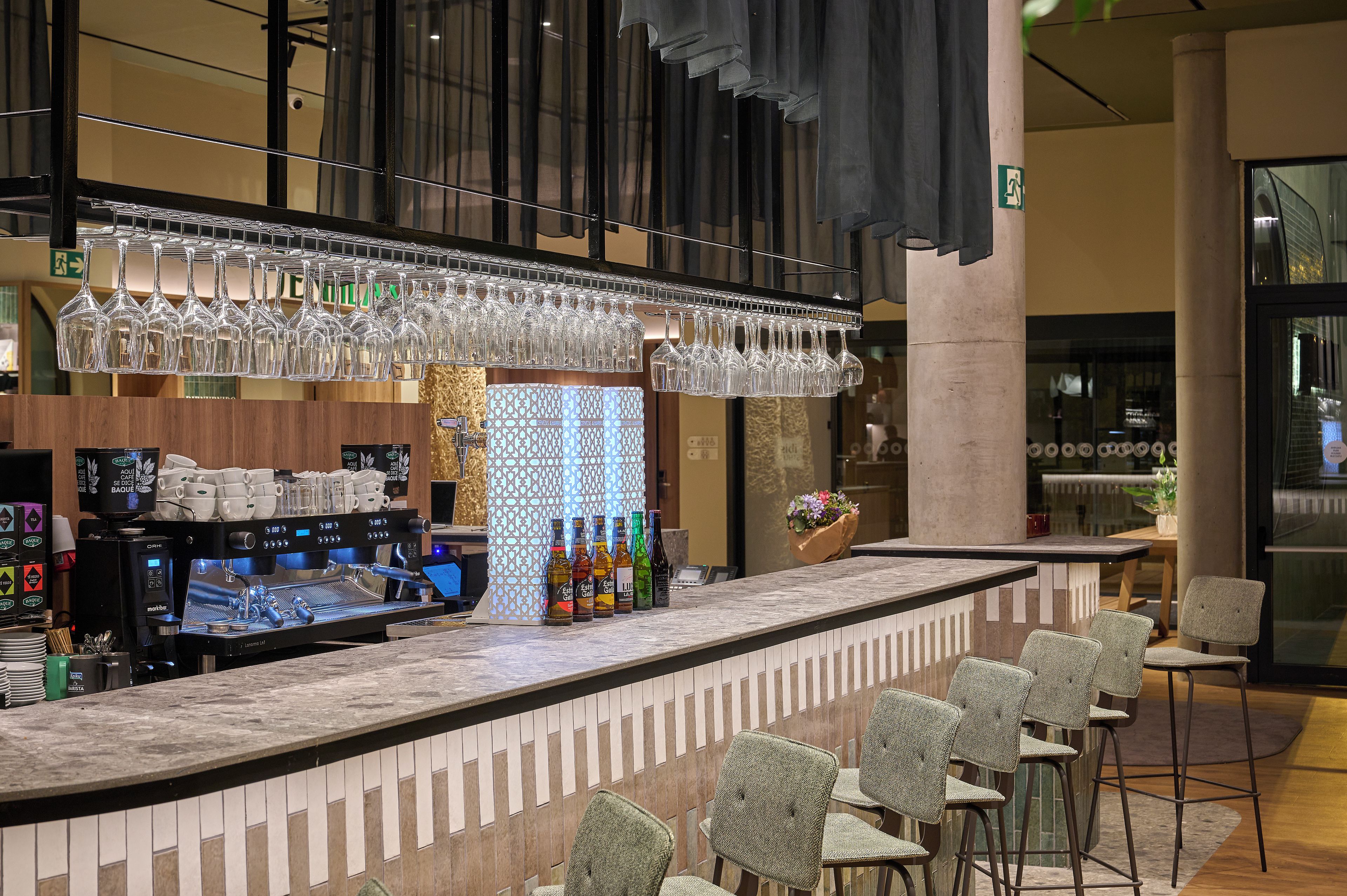 A bar area with a counter, bar stools, and a coffee machine.
