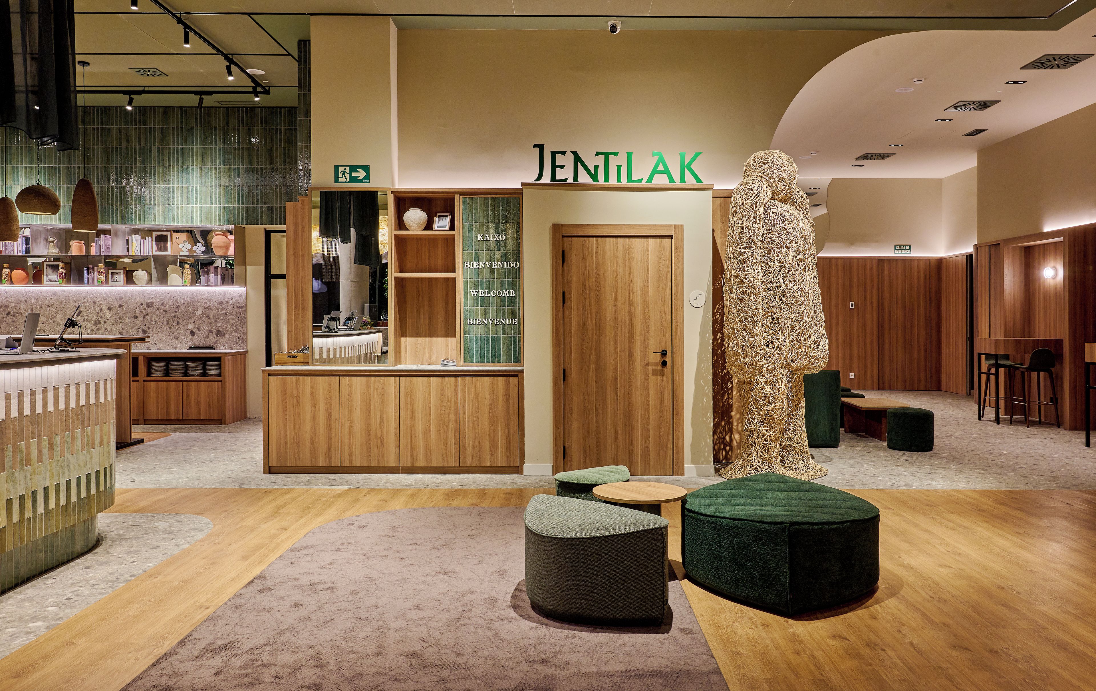 A reception area with a wooden counter, a reception desk, and a sign reading 'JENTILAK'.