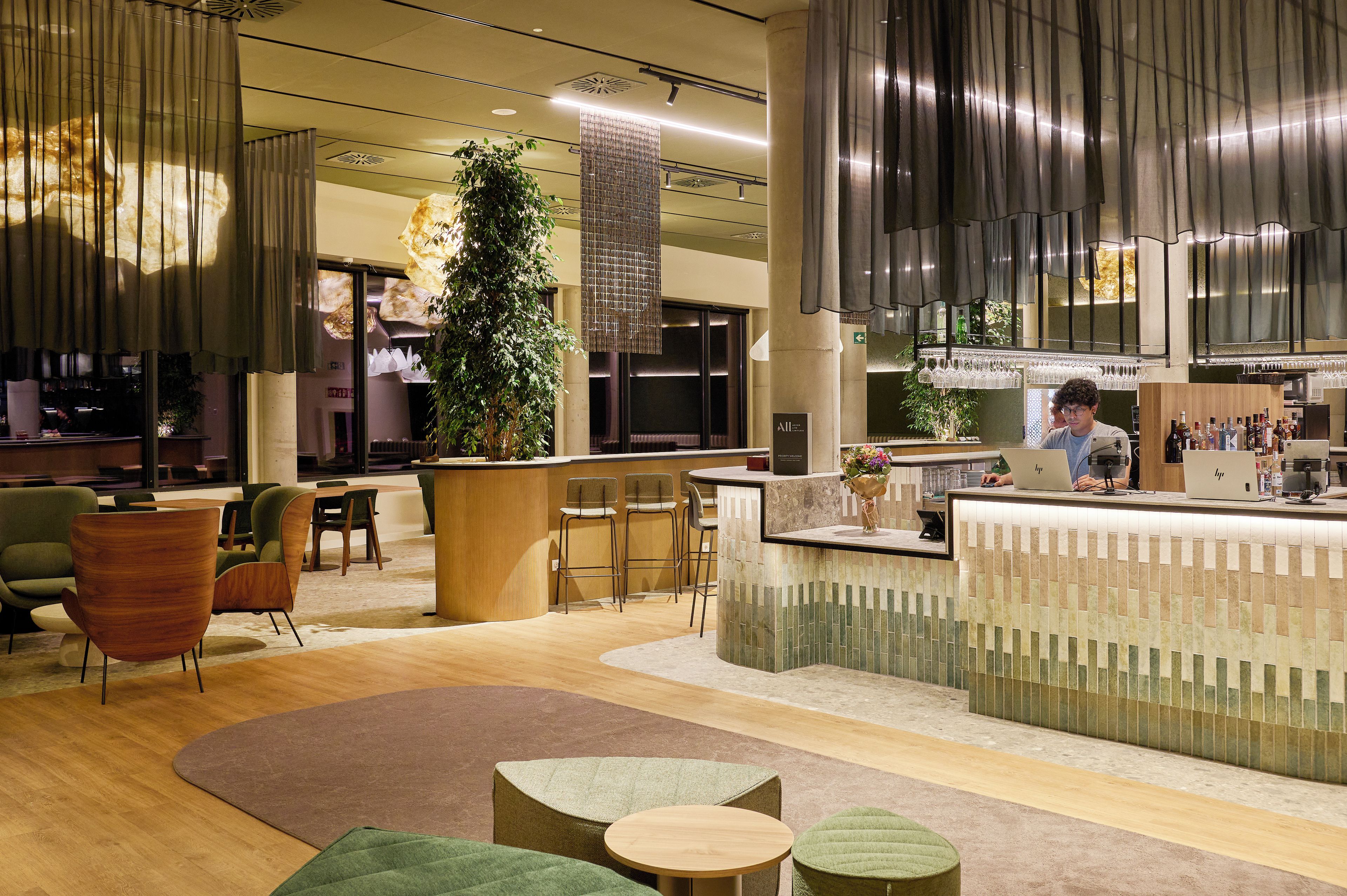 Un interno moderno con una reception, un'area salotto e un bar.