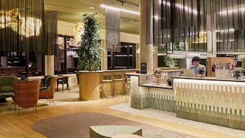 Un interno moderno con una reception, un'area salotto e un bar.