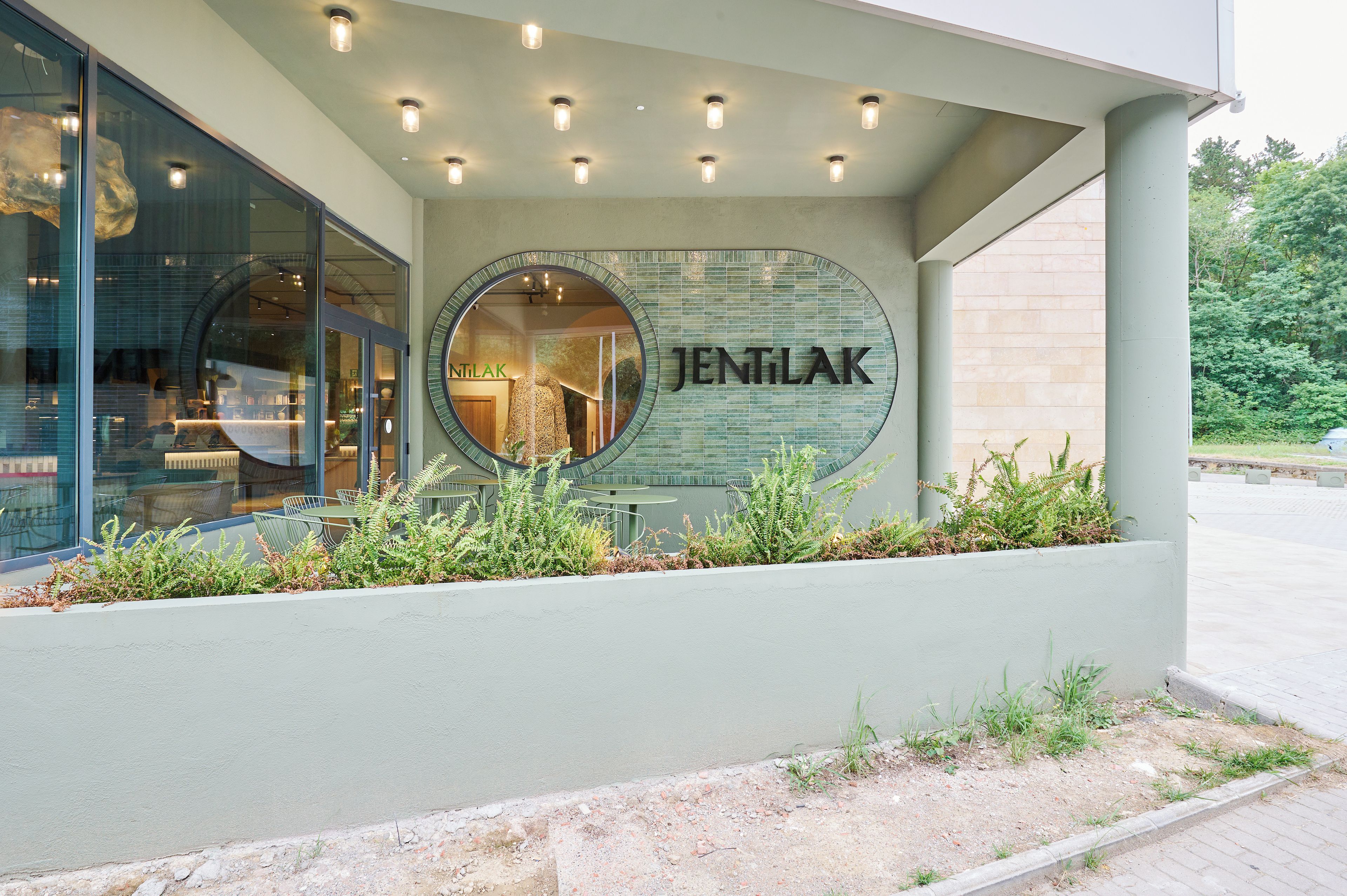 A building with a circular sign reading 'JENTILAK' and a glass facade.