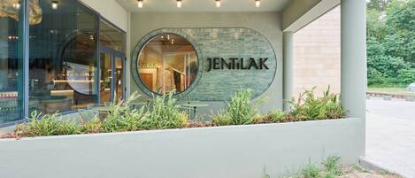 A building with a circular sign reading 'JENTILAK' and a glass facade.