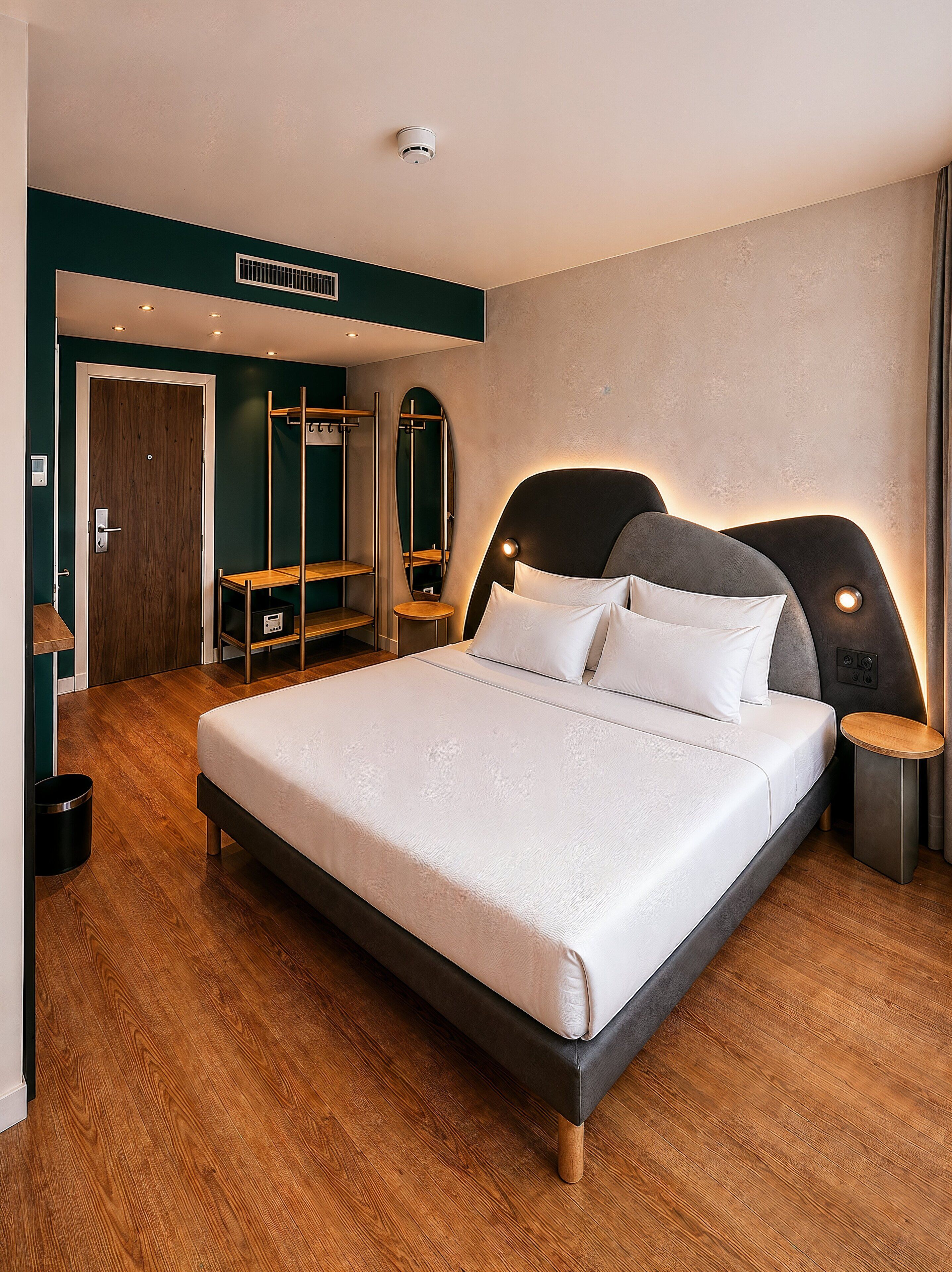 Une chambre moderne avec un grand lit, un plancher en bois, une armoire intégrée et un miroir.