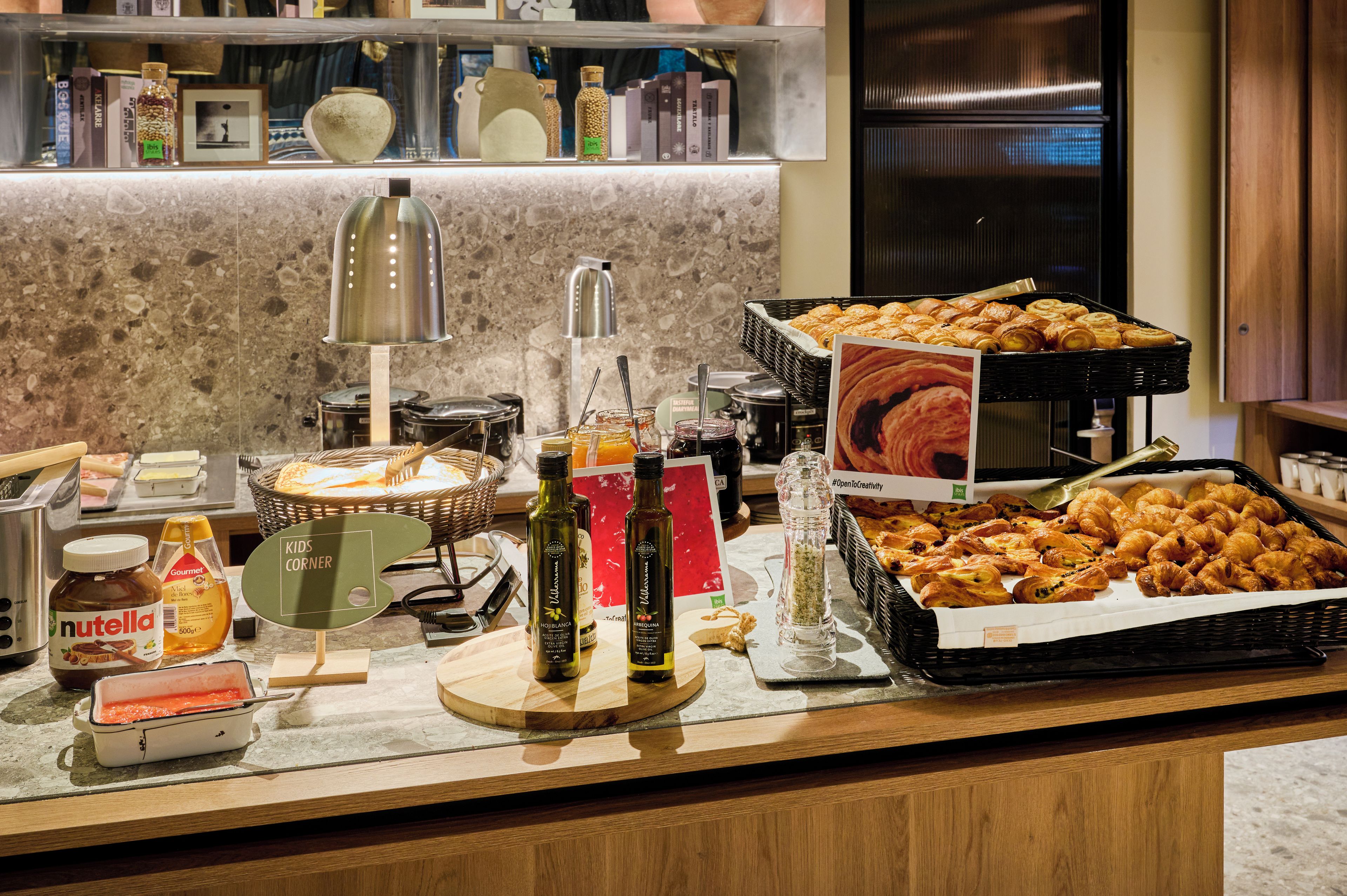A buffet setup with various food items, condiments, and a coffee station.