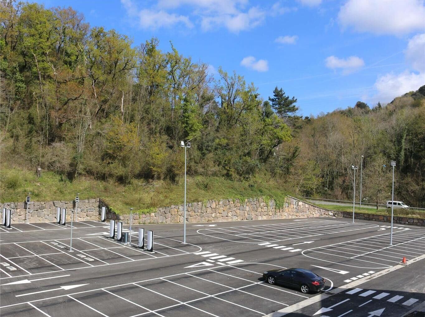 Un parking avec des places délimitées et une voiture garée sur l’une d’elles.