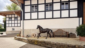 Ein Gebäude mit einer traditionellen Fassade, einer Pferdestatue und einer Bank.