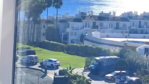 A residential area with a view of the ocean, parked cars, and buildings with balconies. - Algaida Beach Send Litoral Studio with Sea View, Adults Only (Calahonda)