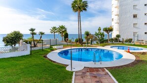 A pool area with two circular pools, surrounded by palm trees and a white building with balconies. - Algaida Beach Send Litoral Studio with Sea View, Adults Only (Calahonda)