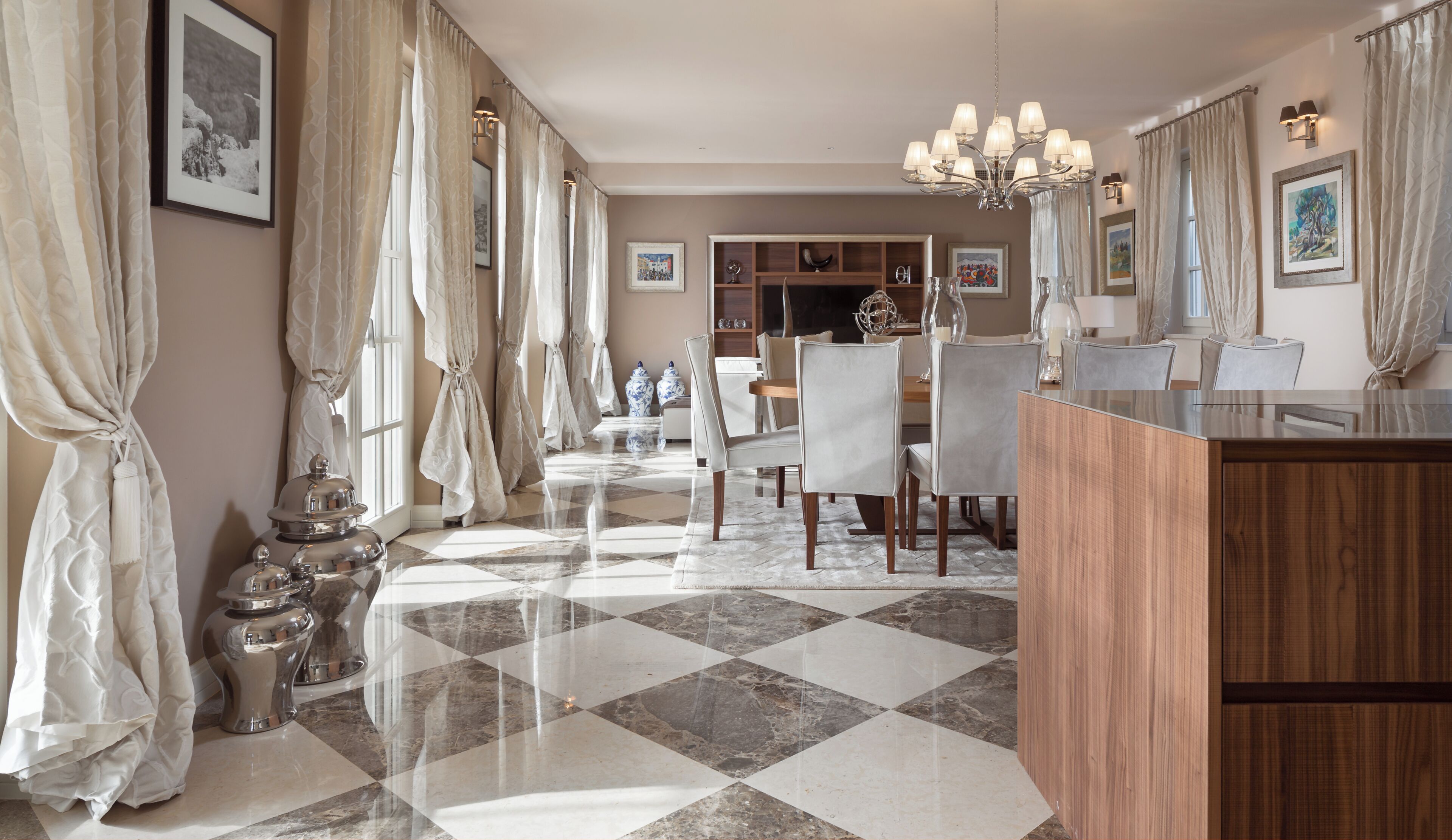 Une chambre d’hôtel avec un sol à carreaux, un bureau en bois et un coin repas comprenant des chaises et une table.