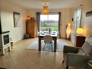 Una sala de estar con chimenea, mesa de comedor y sofá.