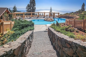 Ein Poolbereich mit freiem Blick auf das Meer und Berge im Hintergrund.