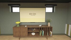 A hotel room with a wooden console table, a large screen displaying 'EH OH HOTEL OFLY RUNGIS,' two wall-mounted lights, and a potted plant. - Hôtel EH OH Orly Rungis (Rungis)