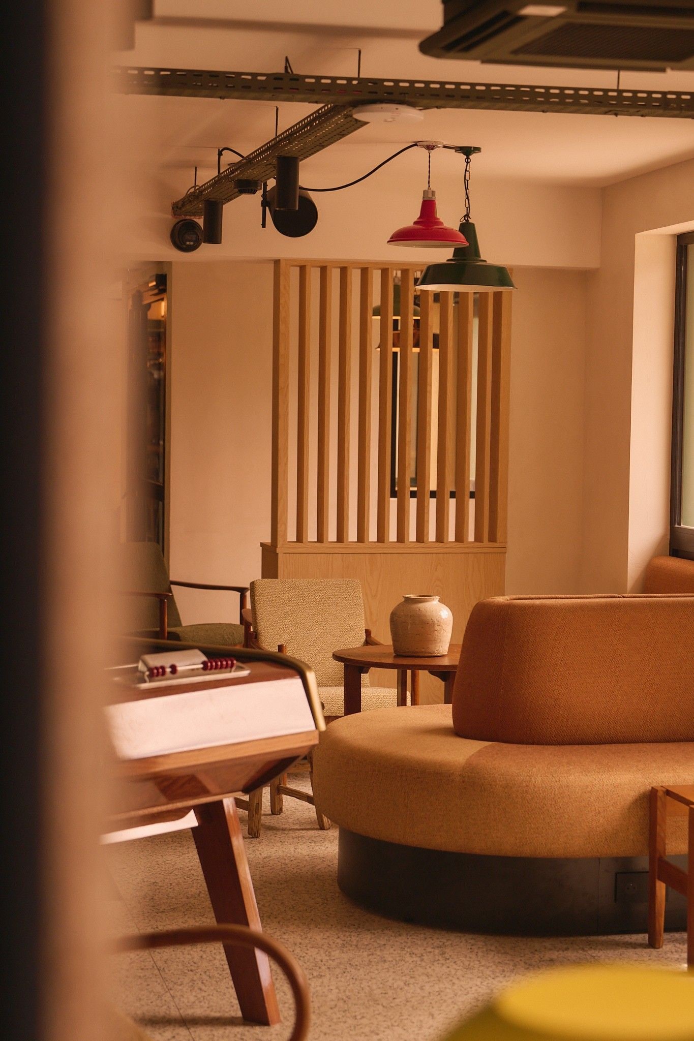 A cozy living room with a sofa, a chair, a small table, and a decorative wall panel.