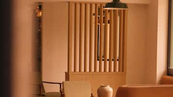 A cozy living room with a sofa, a chair, a small table, and a decorative wall panel.