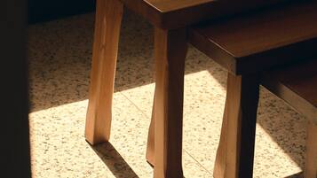 Una mesa de madera con una taza, un platillo y un libro encima.