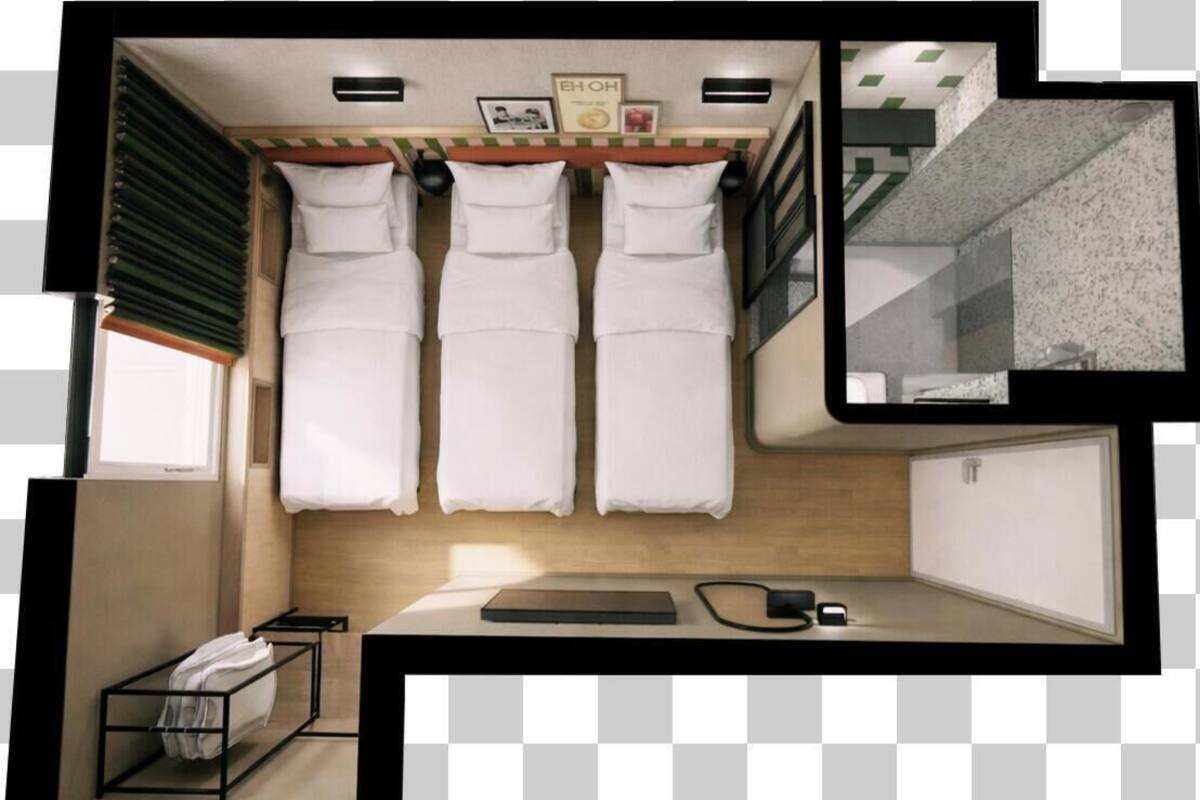A compact hotel room with two beds, a small desk, a window, and a bathroom.
