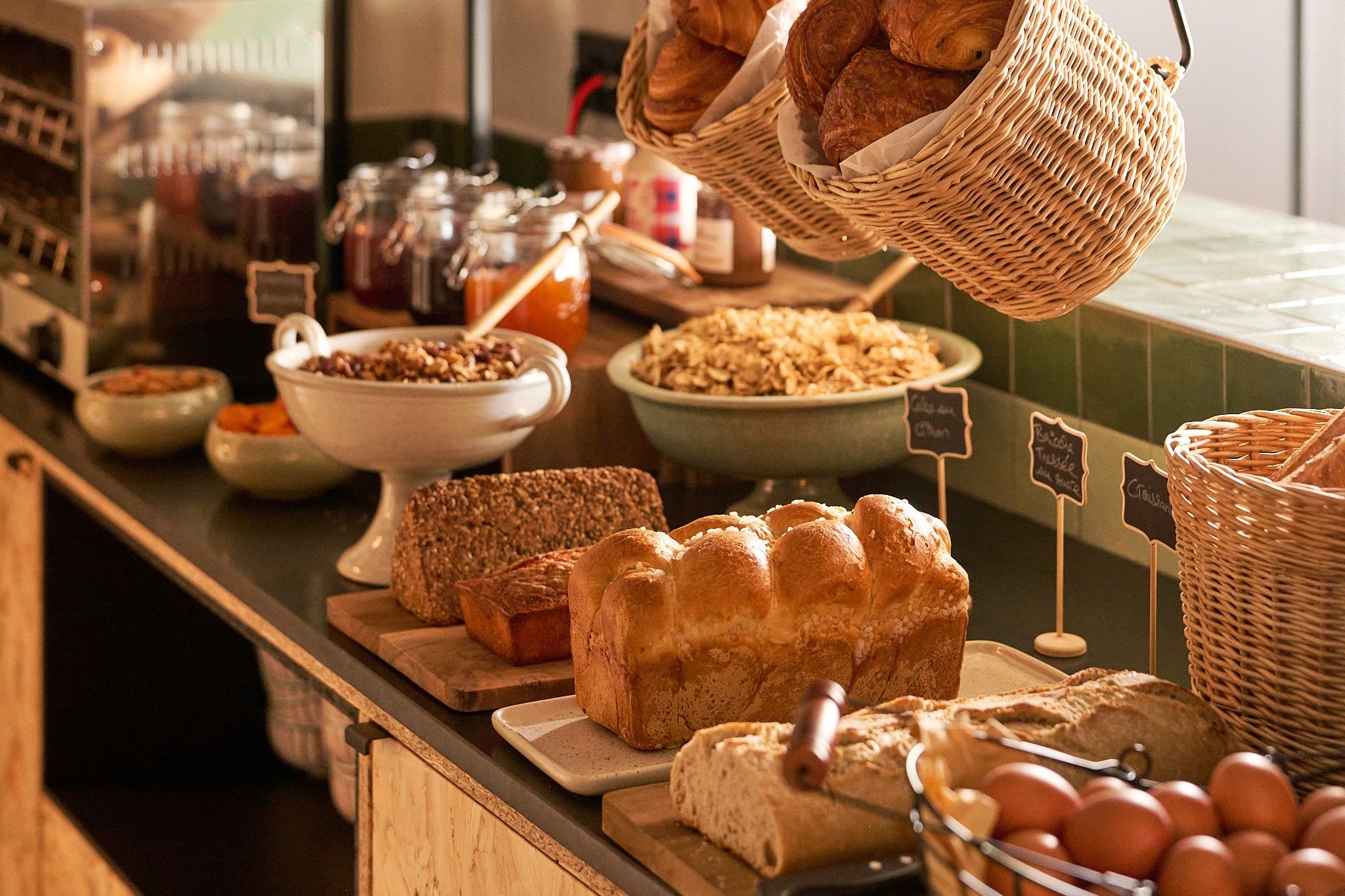 A bakery counter with various breads and pastries, including a loaf of bread and a basket of croissants.