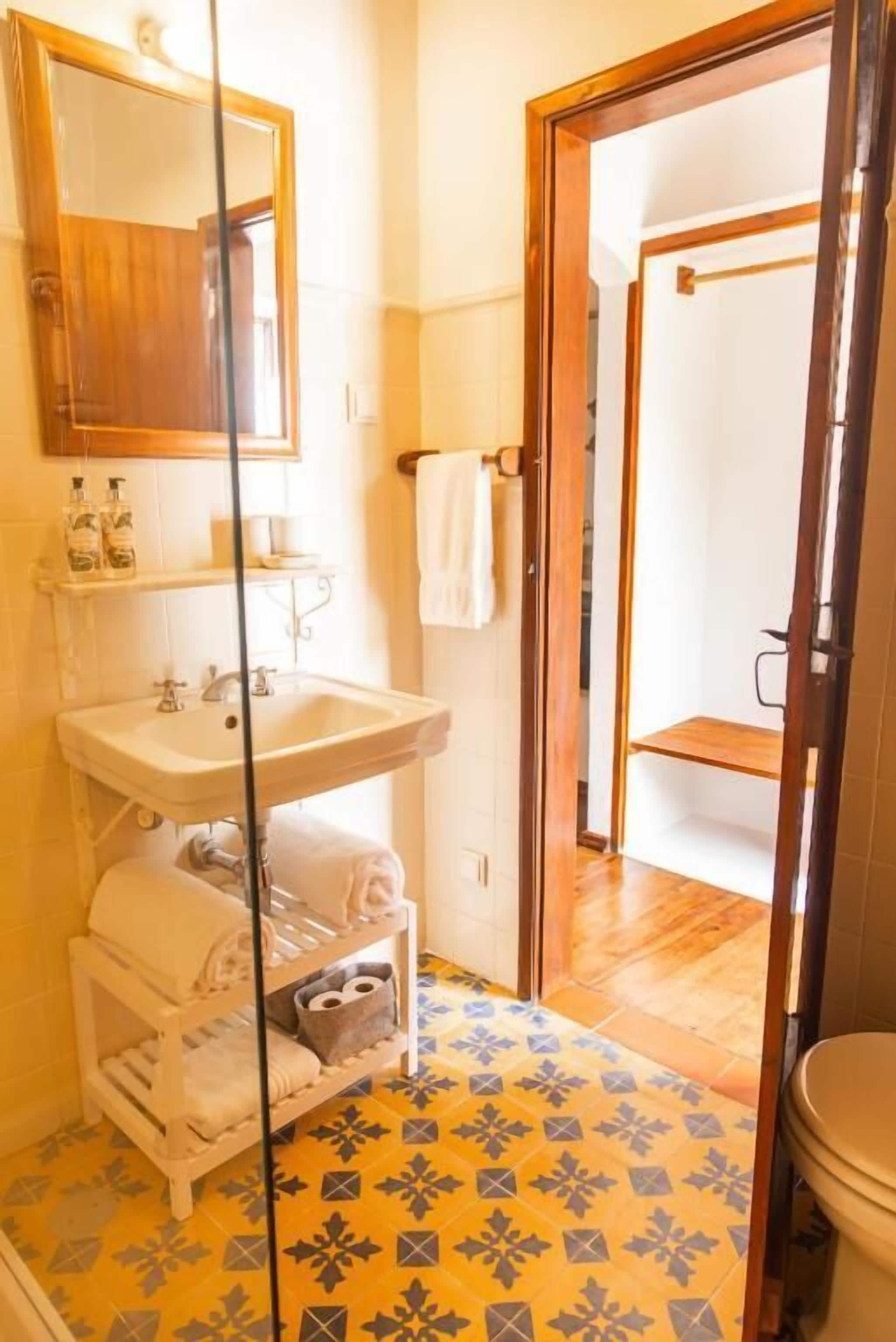 A bathroom with a sink, mirror, and toilet.