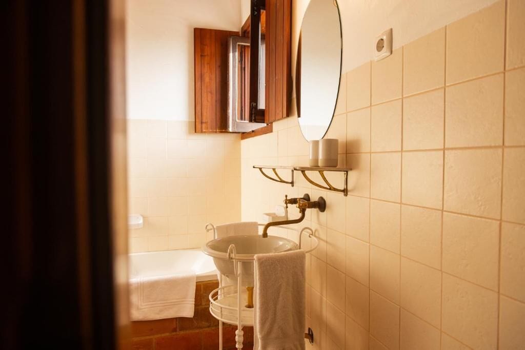 Une salle de bain avec un lavabo, un miroir et un porte-serviettes.