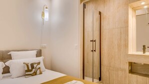 Hotellihuone, jossa on sänky, suihku ja kylpyhuoneen allas.