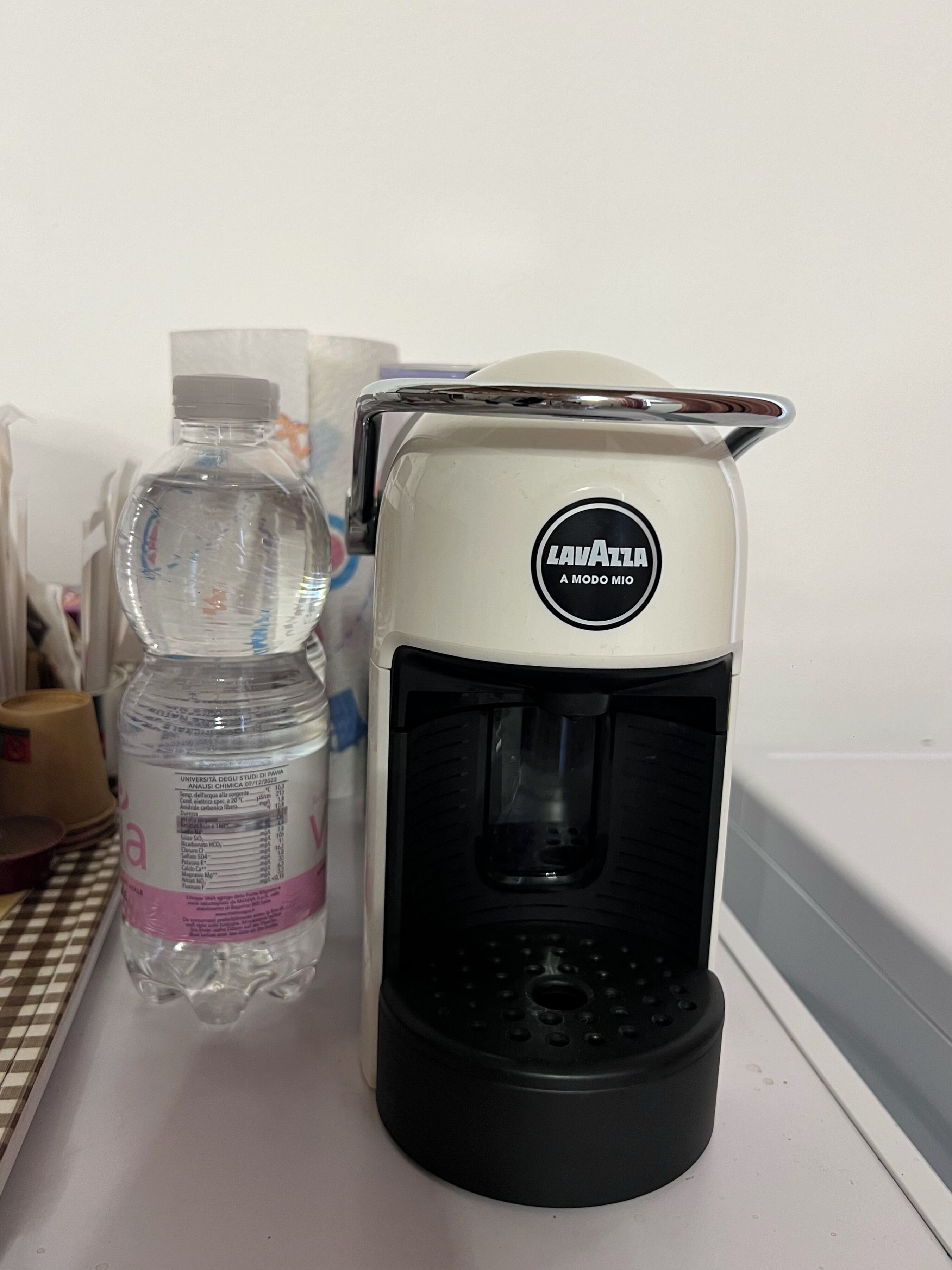 A coffee maker and a water bottle on a counter.