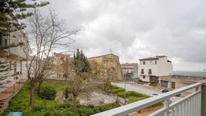 Ein Wohngebiet mit einer Mischung aus moderner und traditioneller Architektur, einem klaren Himmel und Blick auf das Meer.