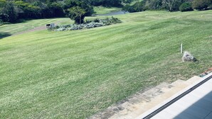 A view of a golf course with a clear sky, lush greenery, and a pathway leading to a pond. - Selborne Golf Estate Villa P15 (Pennington)