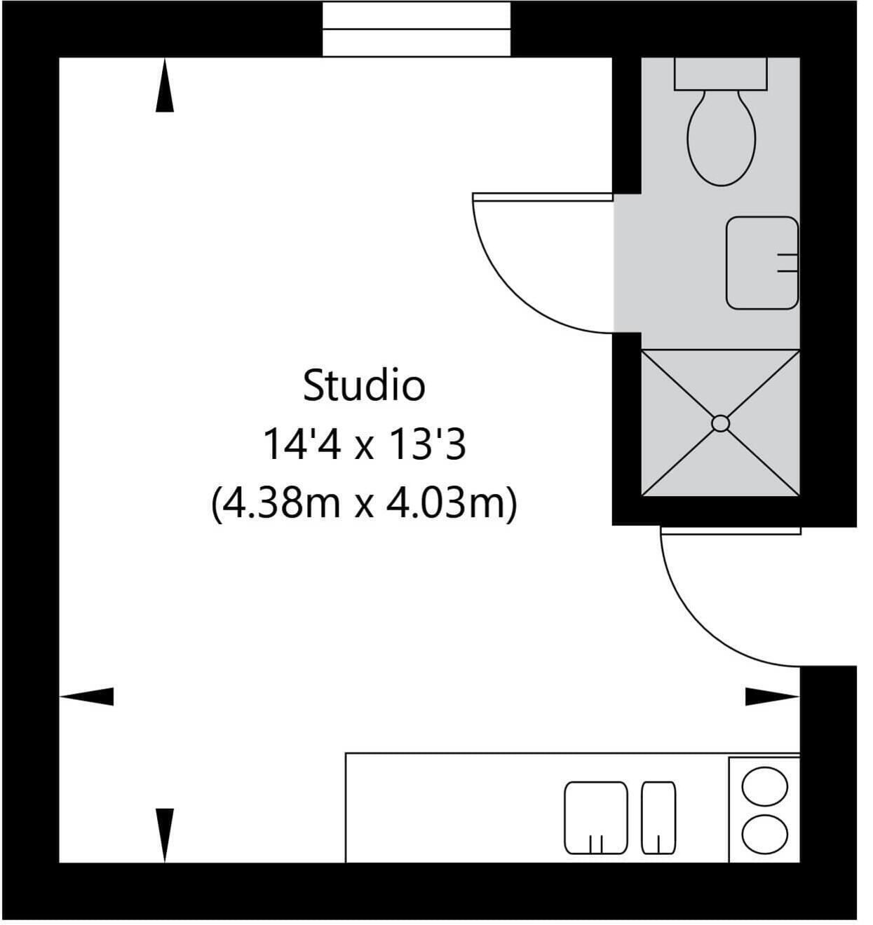 A studio apartment layout with a kitchenette, a bathroom, and a small seating area.