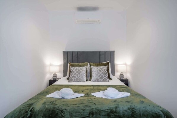 Een hotelkamer met een bed, twee bedlampen, een hoofdeinde en twee handdoeken op het bed.