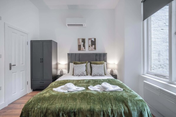 Una camera da letto con un letto, lampade ai comodini, un armadio e una finestra.