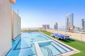 Ein Pool auf dem Dach mit Blick auf die Skyline der Stadt.